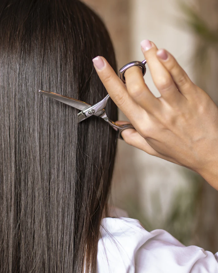 Estilista cortando puntas de cabello largo
