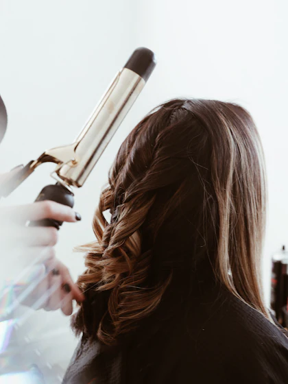 Estilista formando ondas con tenaza
